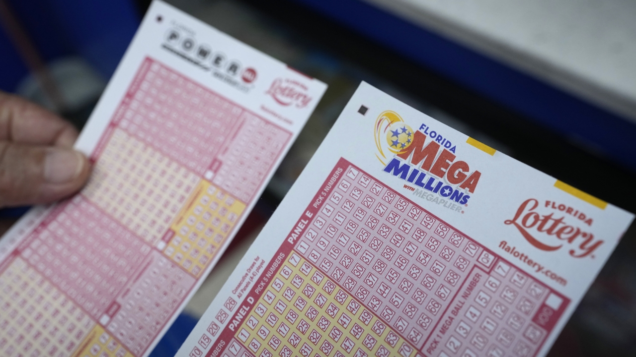 Lottery player holds forms to pick numbers for the Powerball and Mega Millions lotteries