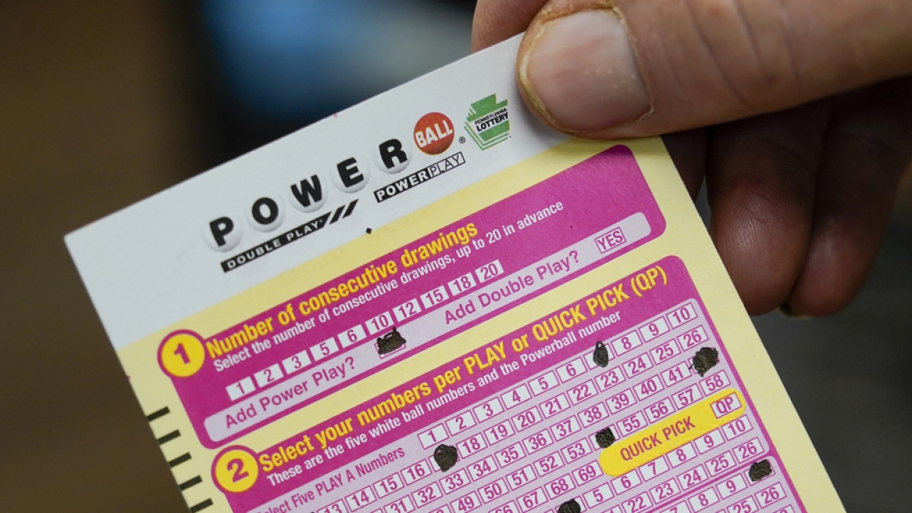 A person shows their scan card for their personal selection numbers for a ticket for a Powerball drawing.