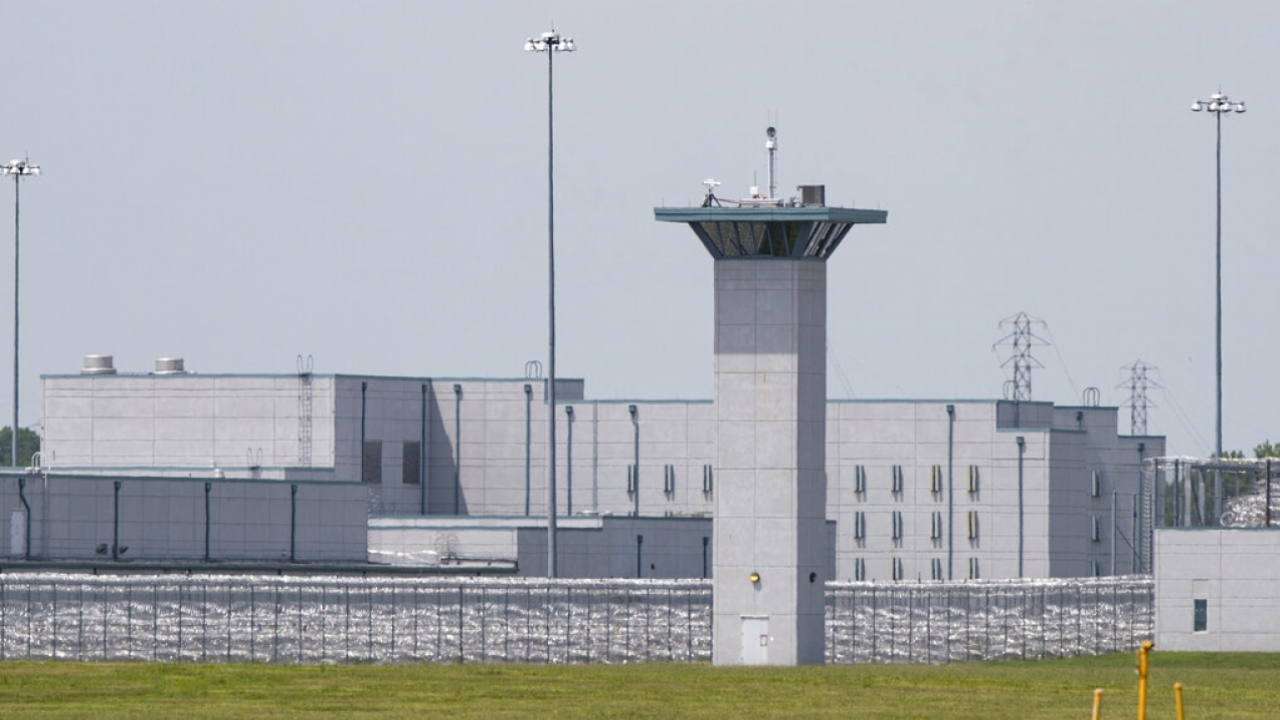 A large gray prison with a watchtower in the forefront.