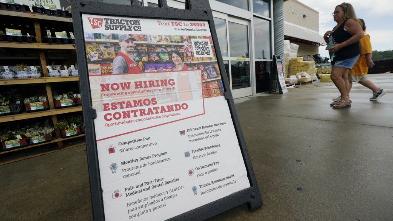 A sandwich sign indicates the need for bilingual Spanish-speaking applicants for jobs at a Tractor Supply Co.