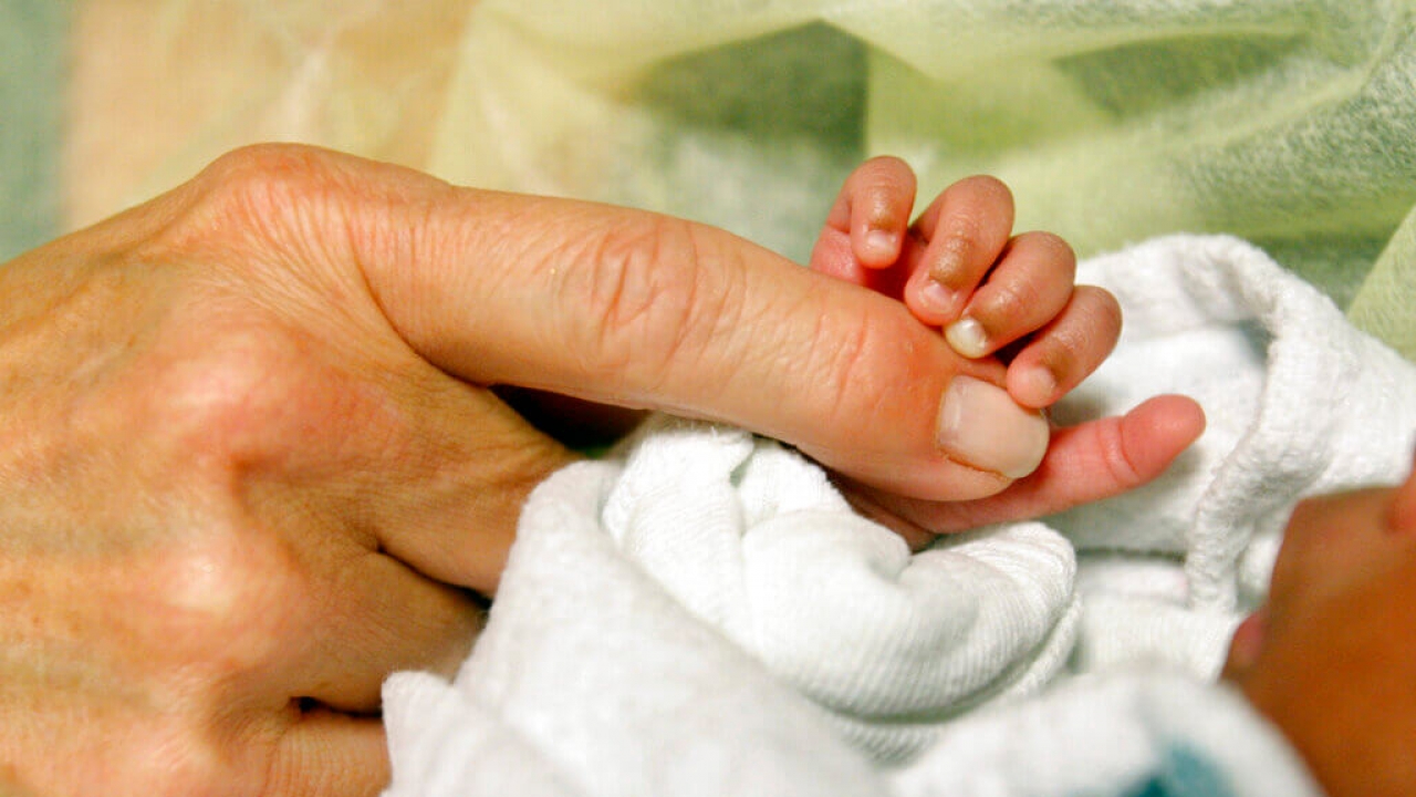 A volunteer cuddles a newborn baby in the hospital