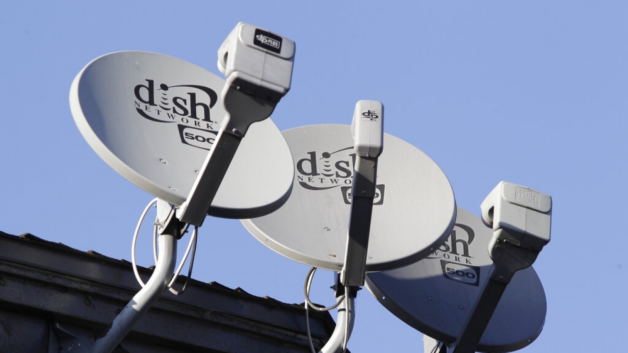 Dish Network satellite dishes are shown at an apartment complex in Palo Alto, Calif.