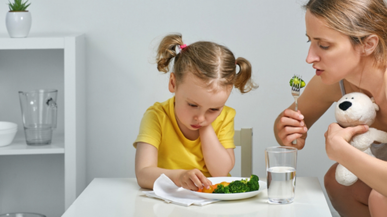 Stock image of a child refusing to eat vegetables.