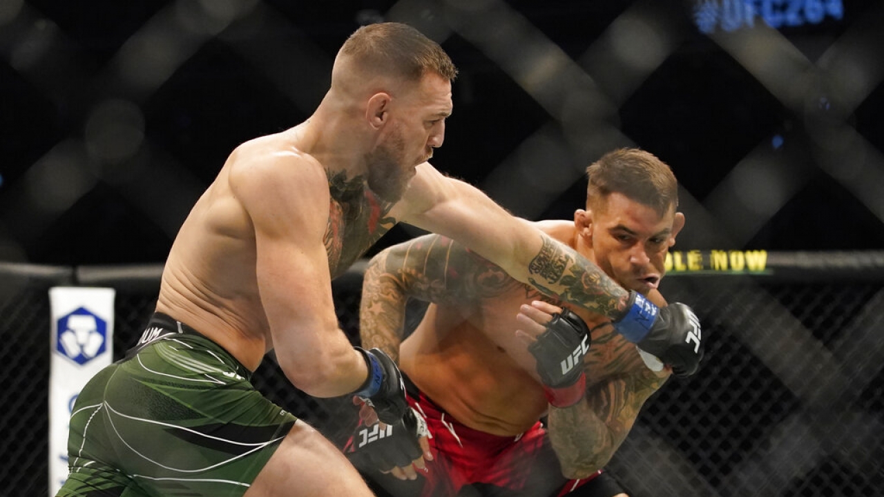 Conor McGregor, left, punches Dustin Poirier during a UFC 264 lightweight mixed martial arts bout.