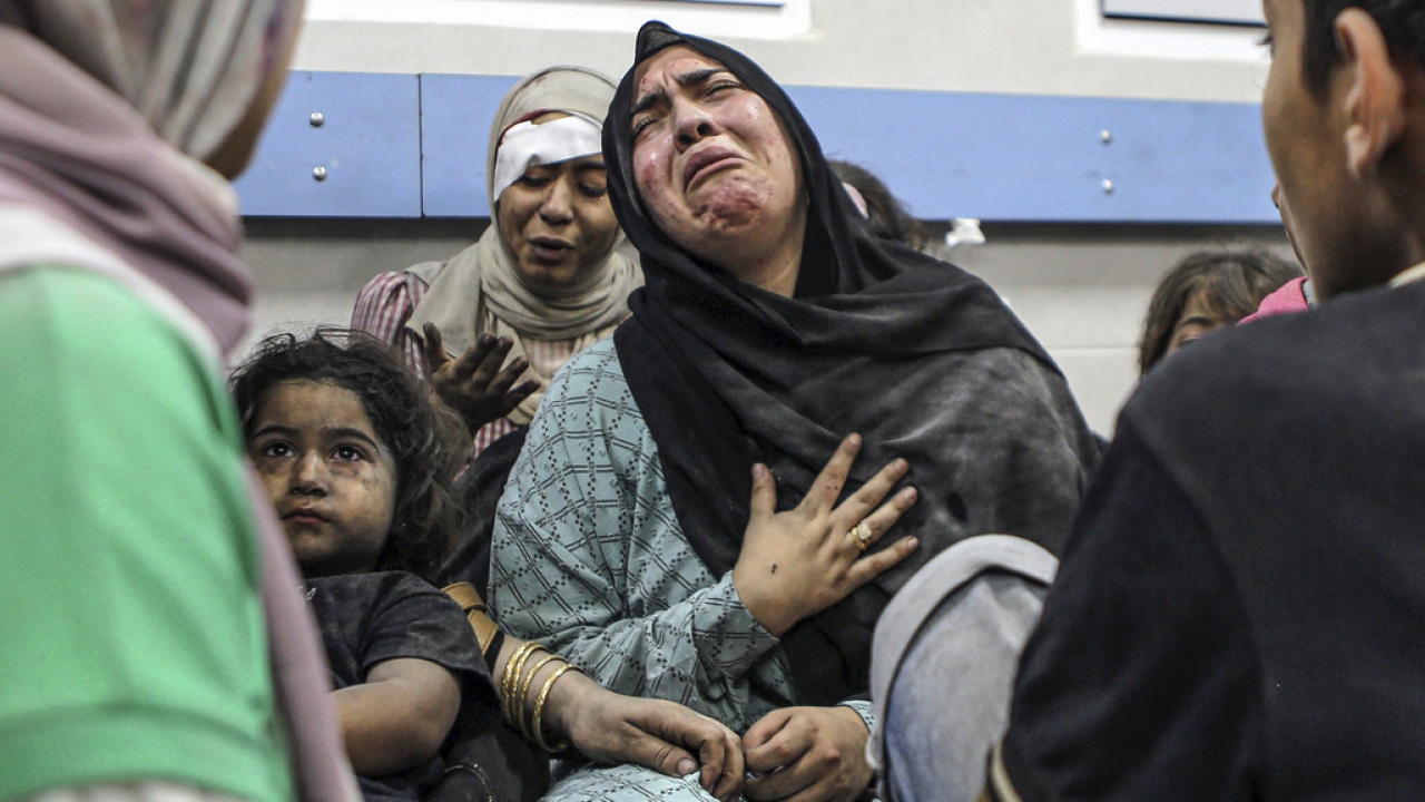 A Palestinian woman cries among other wounded people at a hospital in Gaza