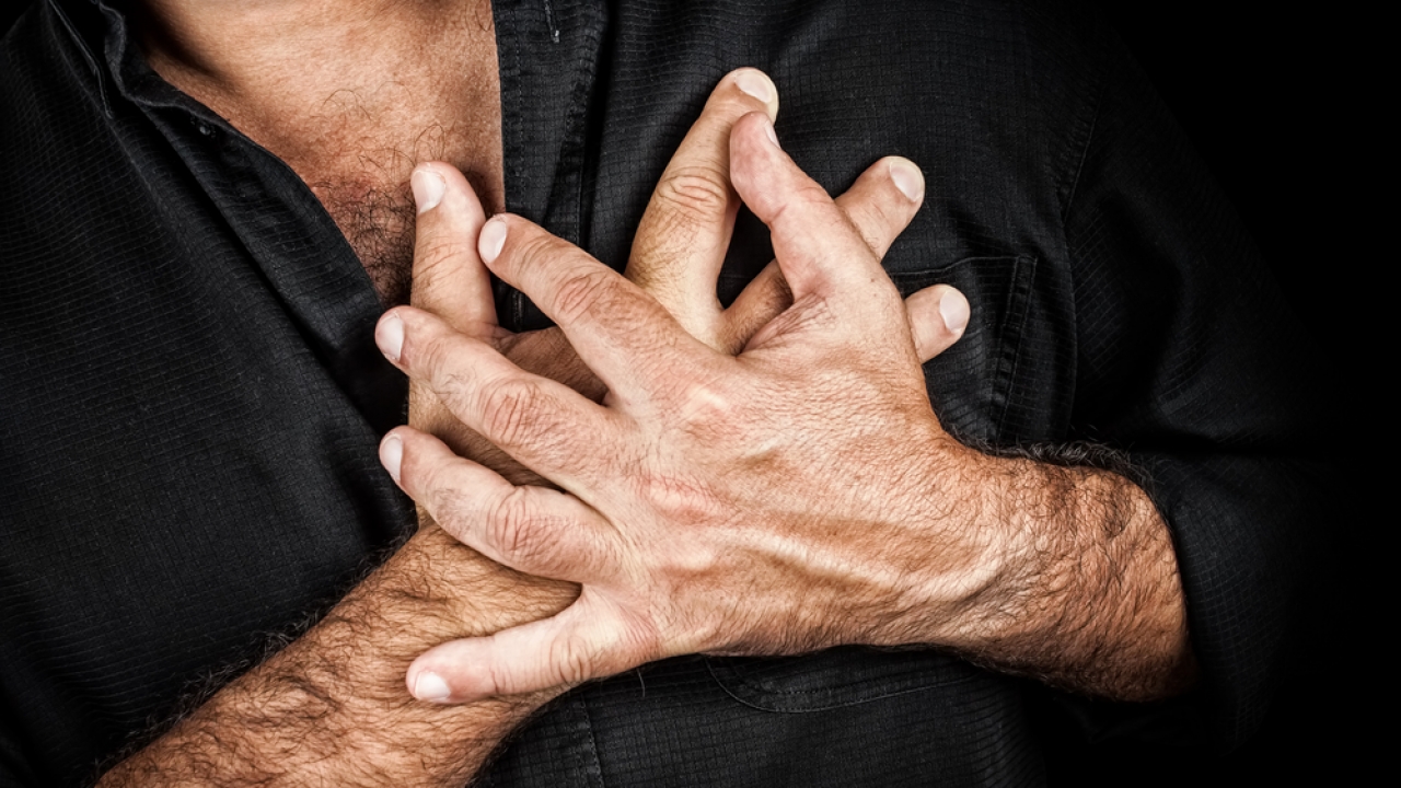 Man clutching chest with both hands