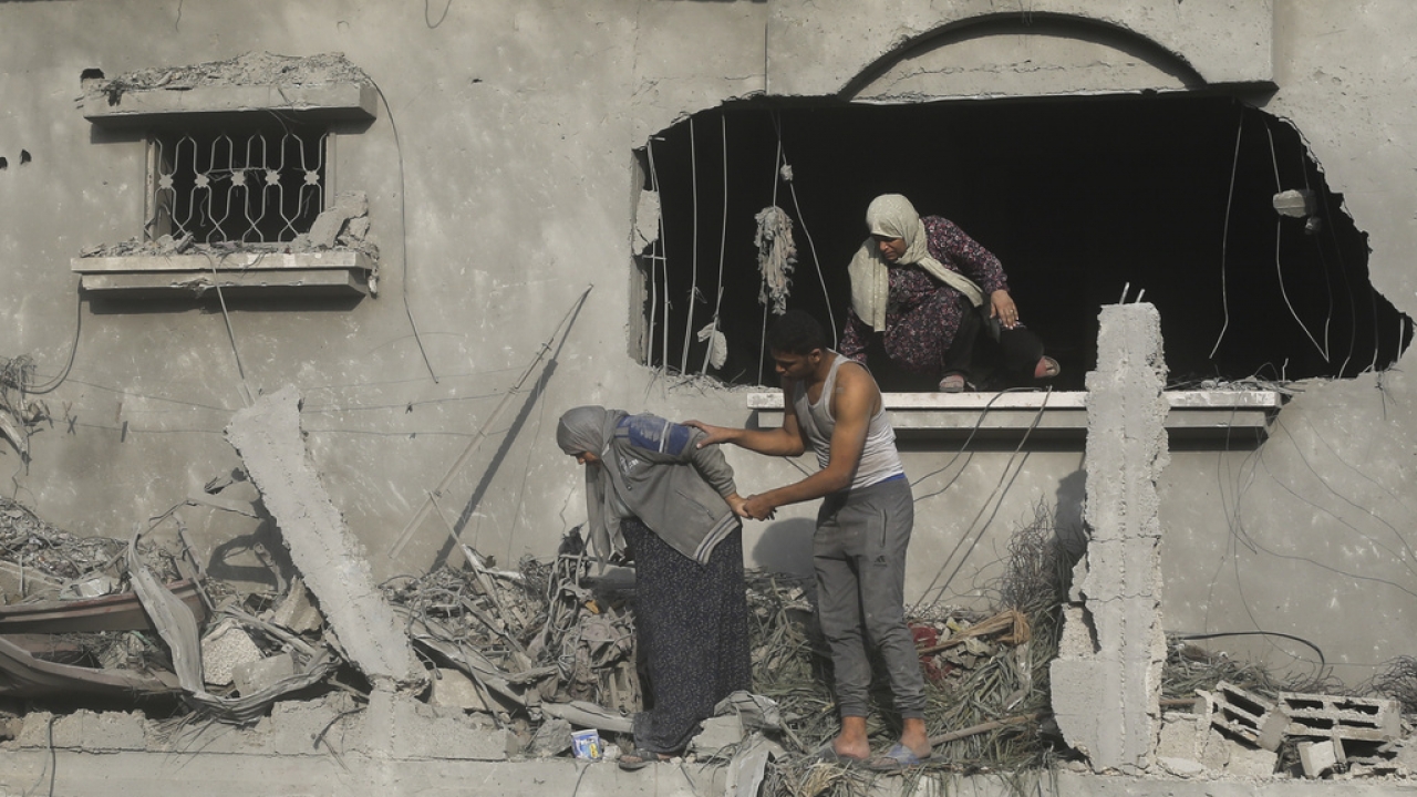 Palestinians evacuate a building damaged in the Israeli bombardment of the Gaza Strip