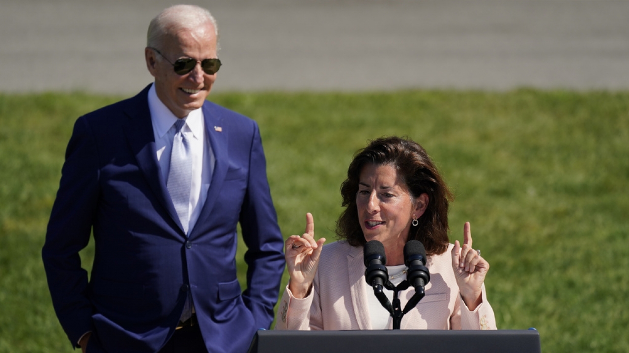 President Joe Biden looks on as Commerce Secretary Gina Raimondo speaks on the South Lawn of the White House.