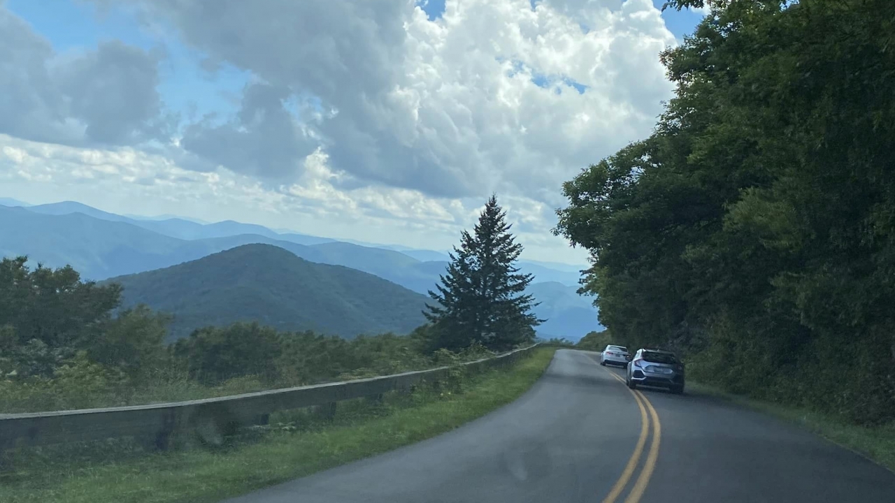 A portion of the Blue Ridge Parkway with cars ahead.