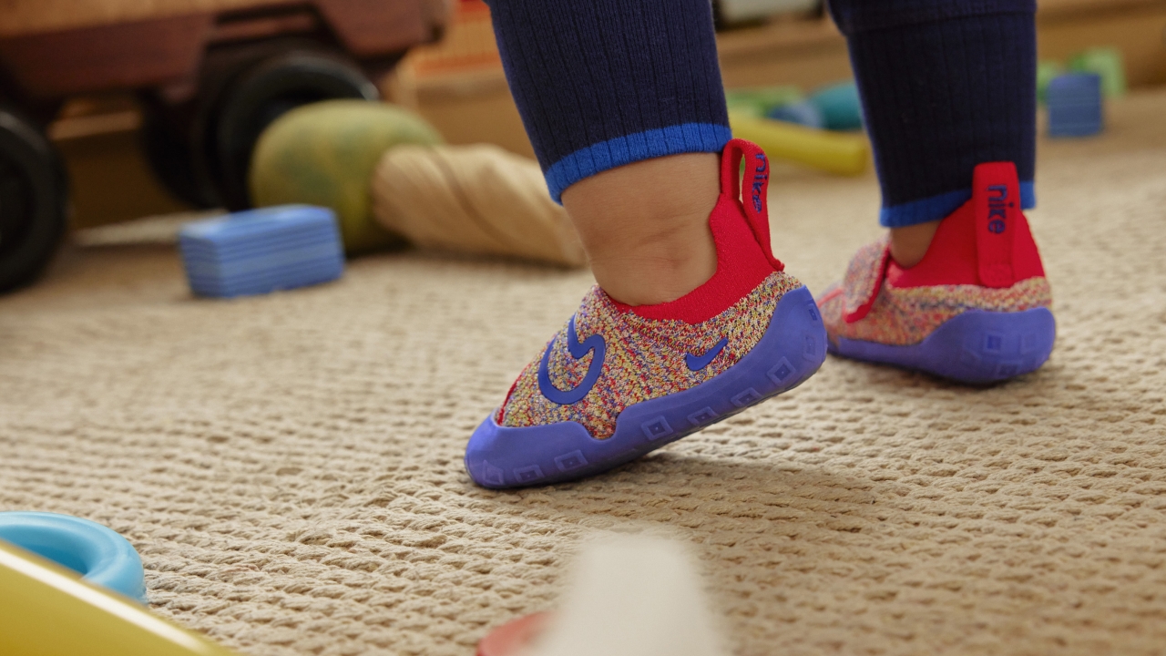 Child wearing Nike Swoosh 1 shoes.