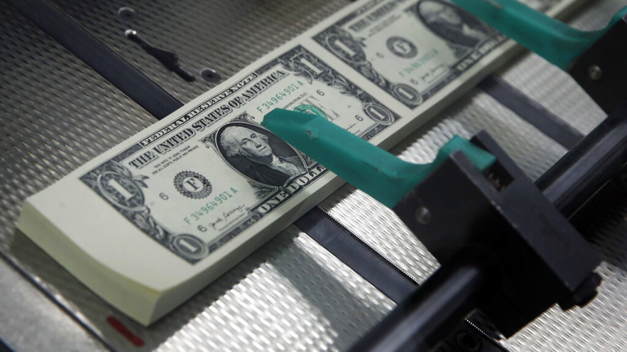 New $1 bills are cut and stacked at the Bureau of Engraving and Printing in Washington.