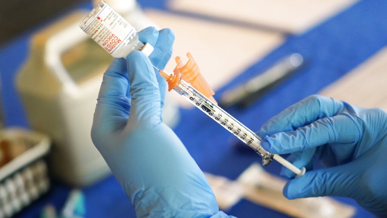 A nurse prepares a syringe of a COVID-19 vaccine.