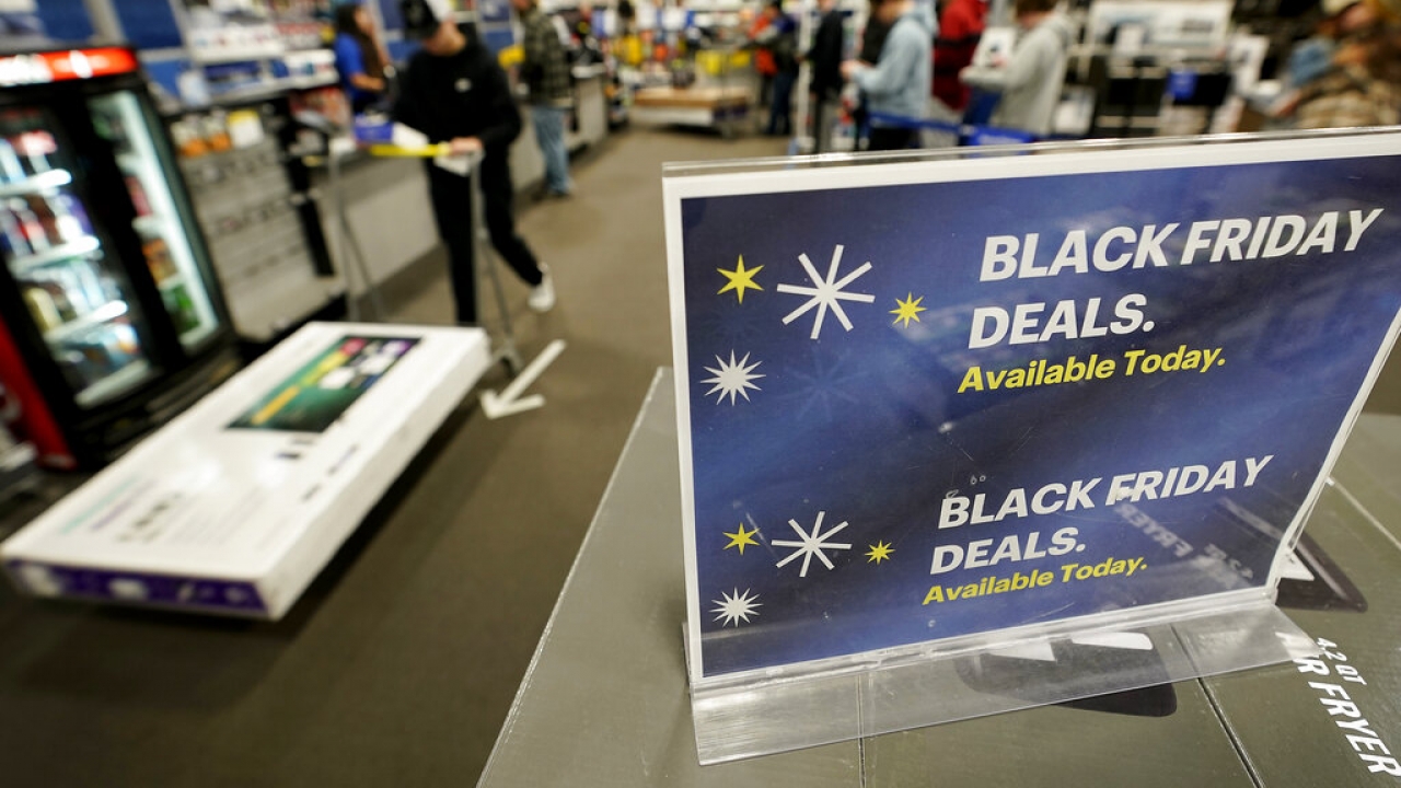 People wait to check out after shopping during a Black Friday sale at a Best Buy.