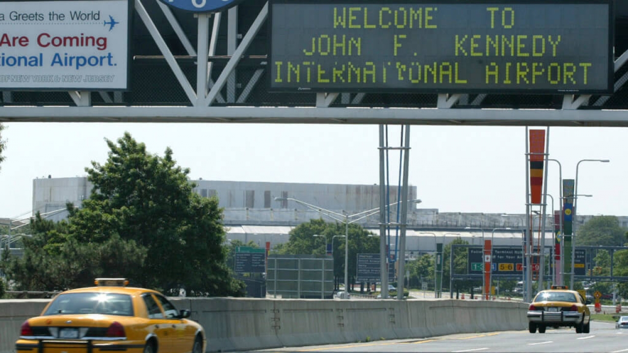 A taxi passes under the entrance to JFK Airport in New York.