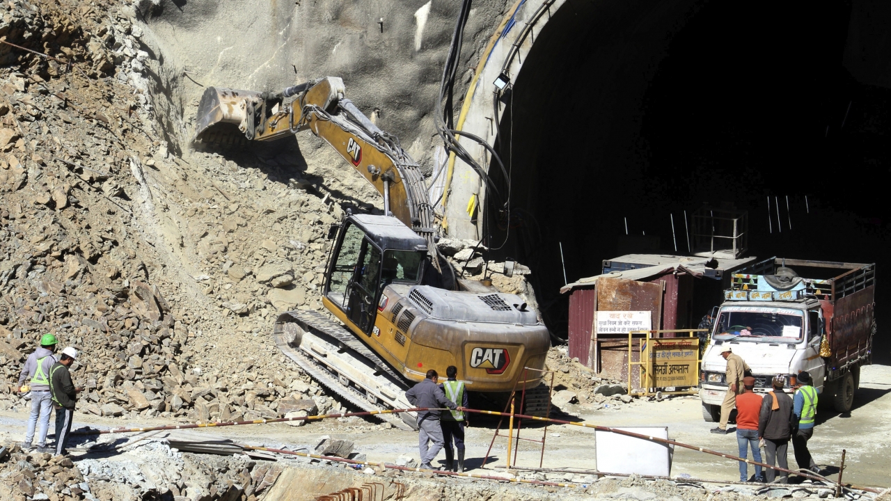 A heavy machinery works at the the entrance to the site of an under-construction road tunnel.