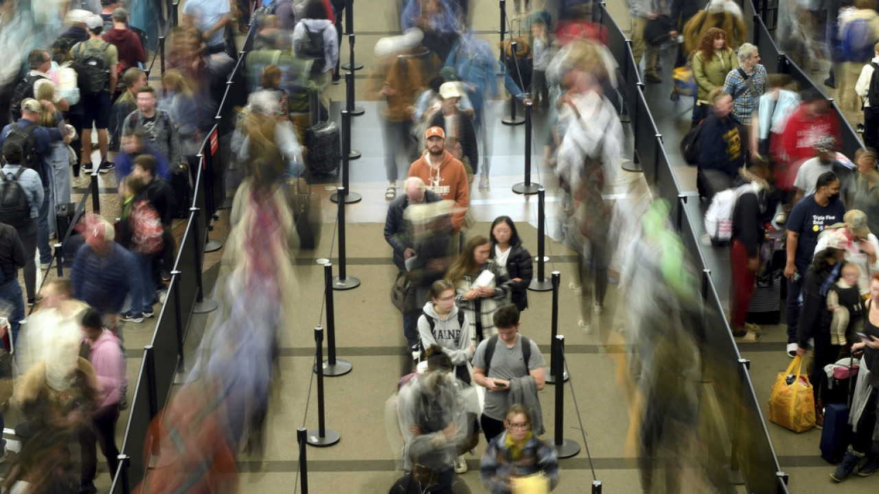 Travelers wait in a security line at Denver International Airport on Tuesday.