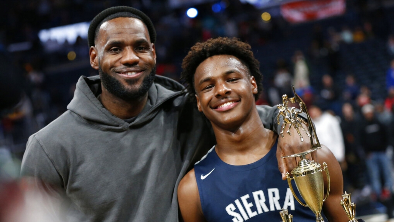 LeBron james, left, poses with his son Bronny after a high school basketball game.