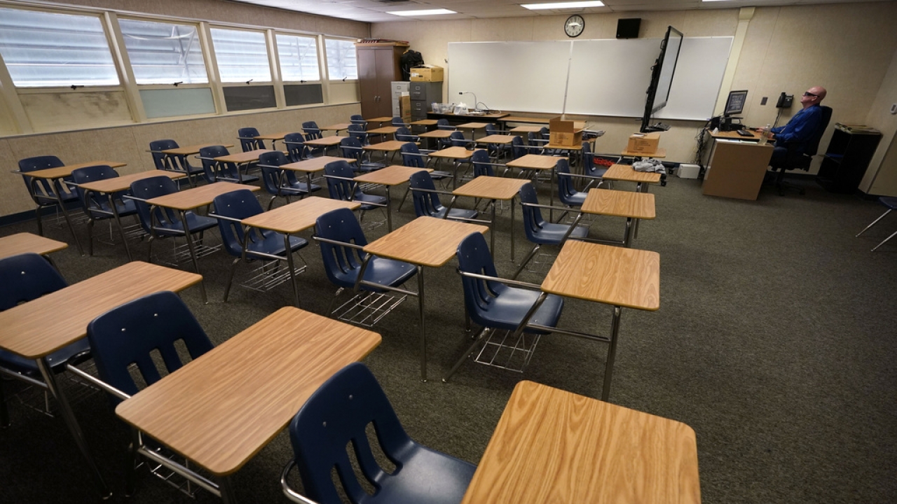 Math teacher Doug Walters sits among empty desks in his classroom.