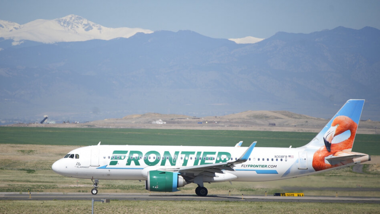 A Frontier Airlines jetliner taxis down a runway at Denver International Airport