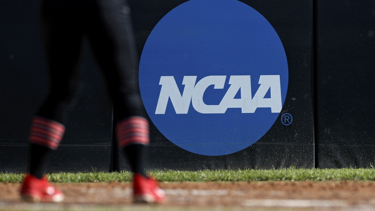 An athlete stands near an NCAA logo during a softball game in Beaumont, Texas.