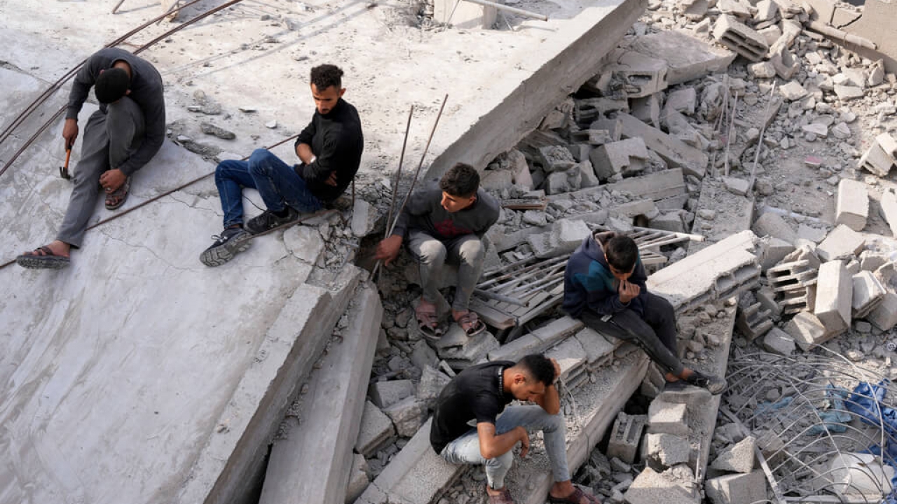 Palestinians sit on the ruins of a destroyed building in the Gaza Strip