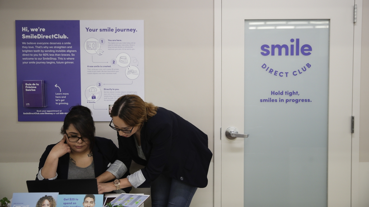 Dental assistants Itzel Barrueta, left, and Jessica Buendia go over appointments at SmileDirectClub's SmileShop.