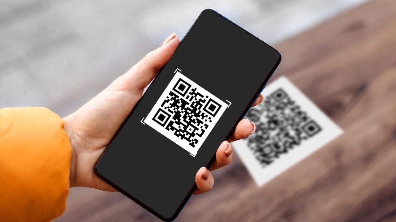 Hand holding a phone scanning a QR code
