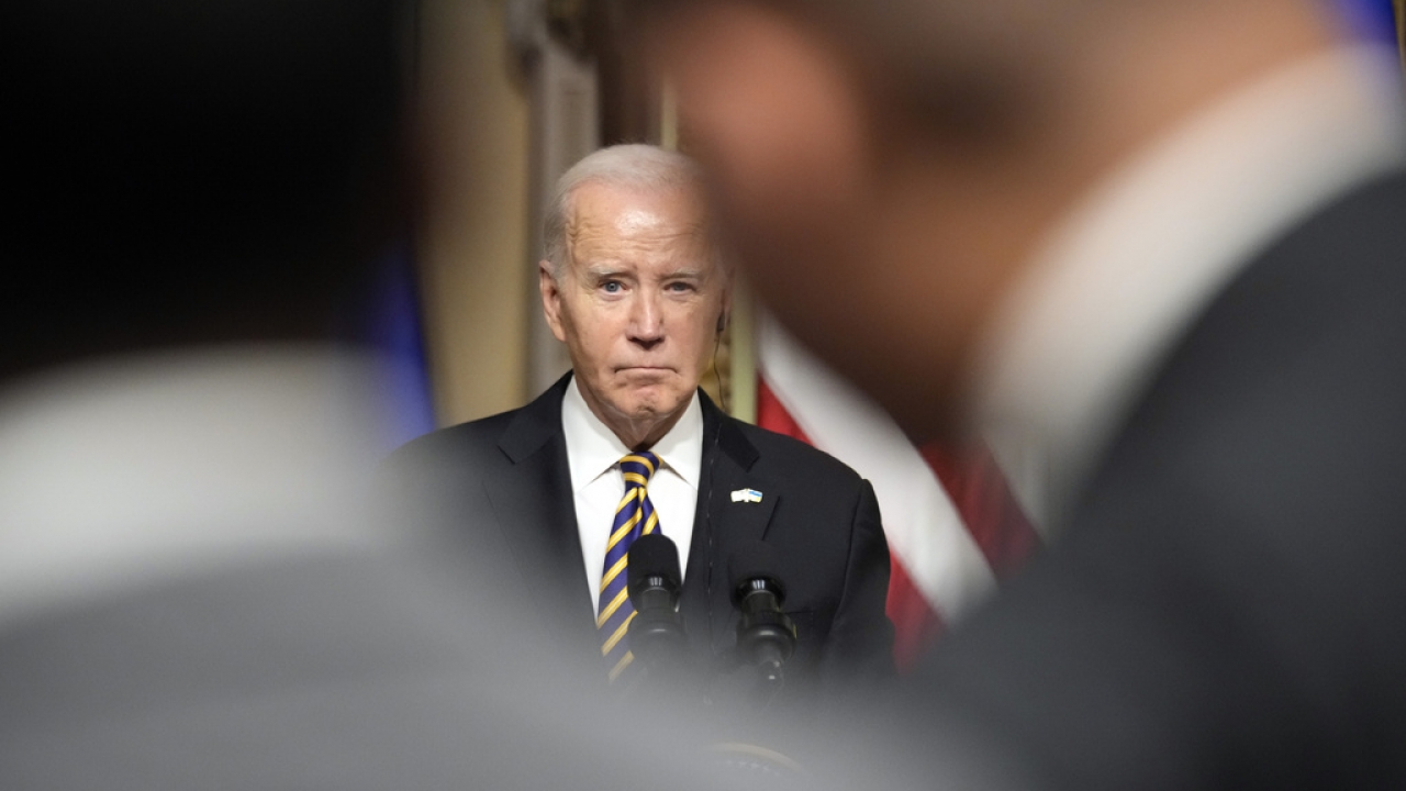 President Joe Biden listens to a question from a reporter during a news conference.