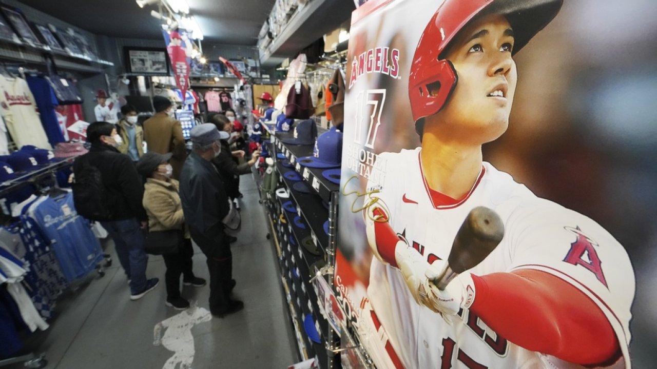 Customers shop for Shohei Ohtani gear at a sporting goods store.