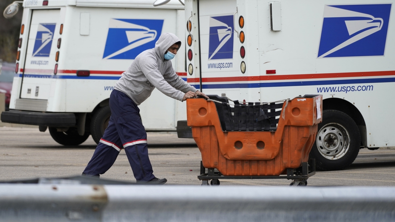 A United States Postal Service employee works outside a post office in Illinois.