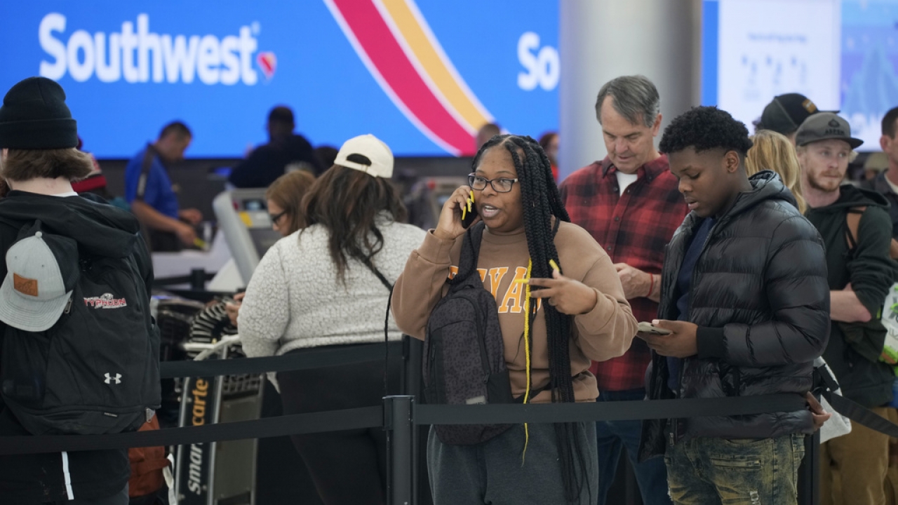 Travelers wait in line for service at the Southwest Airlines check-in counter