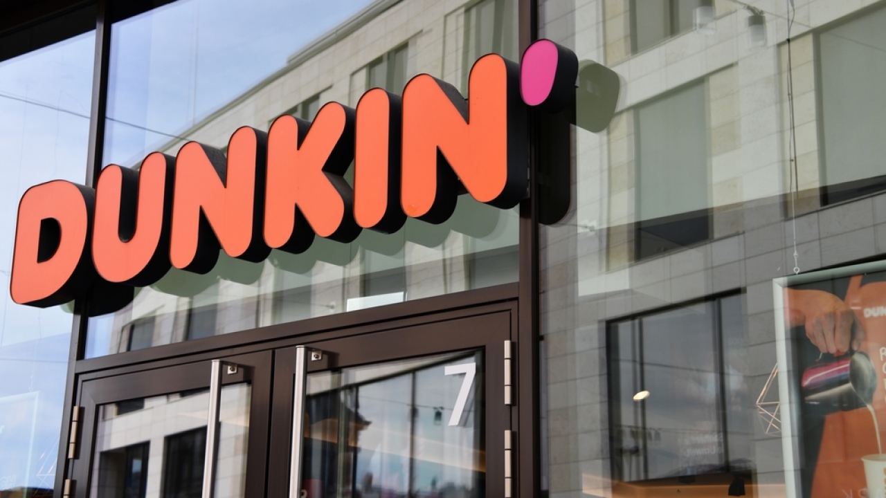 A Dunkin' logo outside of a store.
