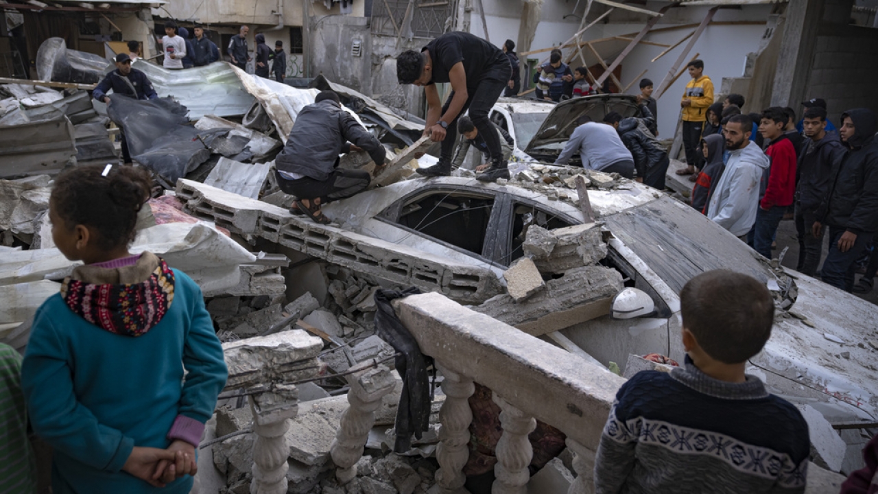 Palestinians inspect a house after it was hit by an Israeli bombardment