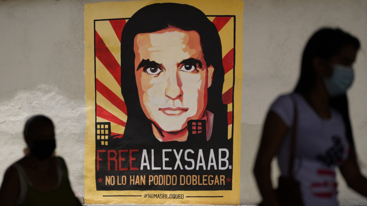 Pedestrians walk near a poster asking for the freedom of Colombian businessman Alex Saab