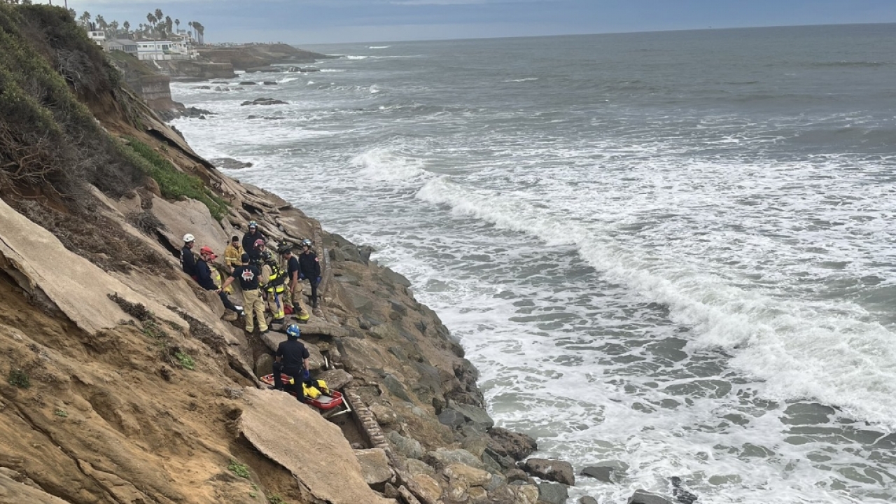 Rescue crews work to free a man who fell in a narrow hole on the side of a cliff in San Diego County.