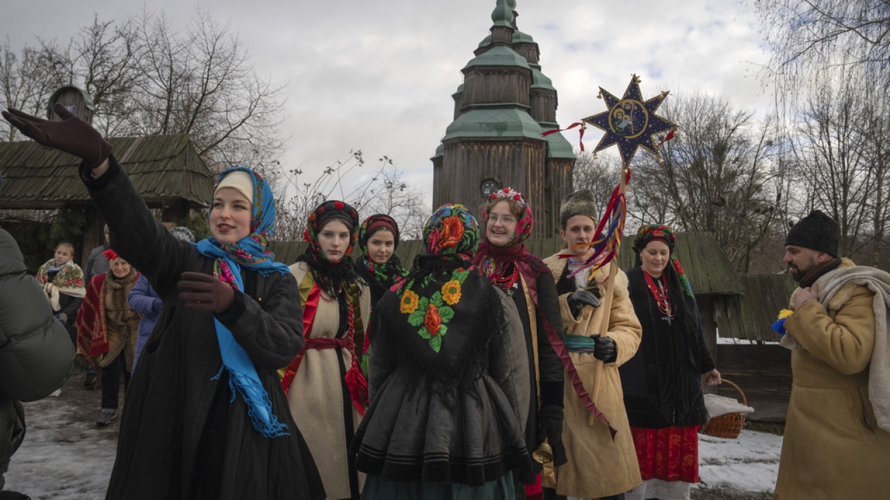 People dressed in national suits celebrate Christmas.