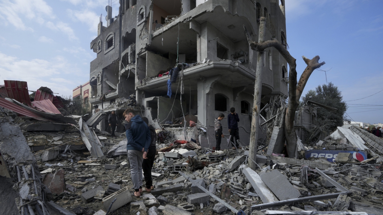 Palestinians inspect the rubble of a building of the Al Nawasrah family destroyed in an Israeli strike in refugee camp.