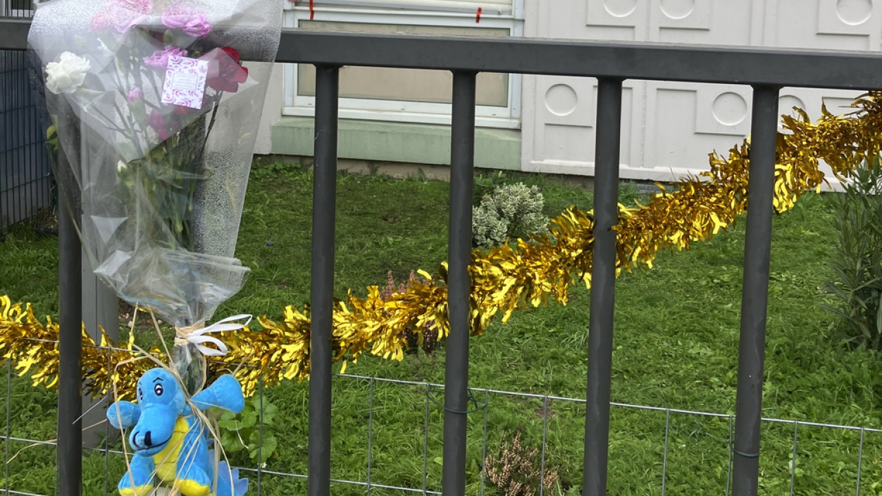 Flowers lay at the building gate where four children between nine months and 10 years old and their mother were found dead.