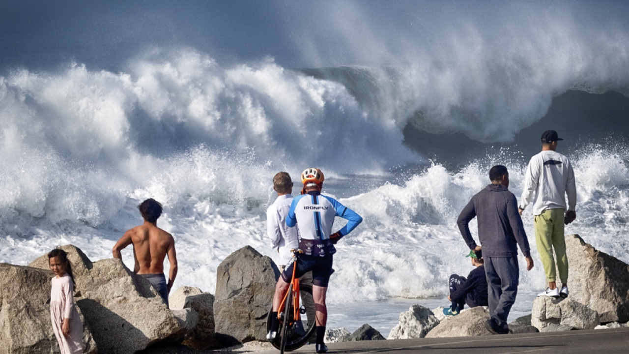 Beachgoers watch as turbulent surf pounds the coast at Manhattan Beach.