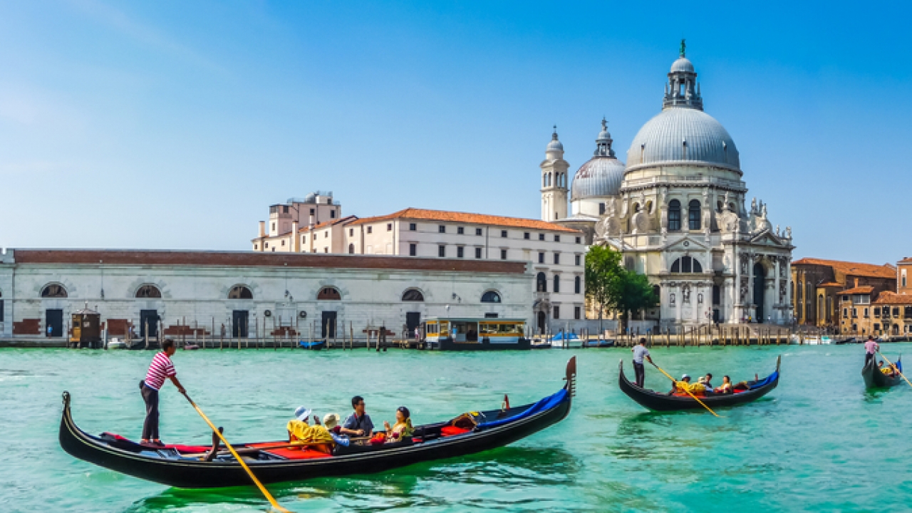 Gondolas on Canal Grande with historic Basilica di Santa Maria della Salute in the background in Venice, Italy