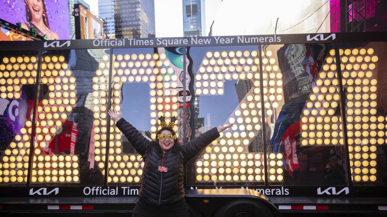 Teresa Hui poses in front of the 2024 New Year's Eve numerals are displayed in Times Square.
