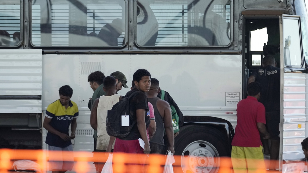Migrants who entered the U.S. from Mexico are loaded onto a bus.