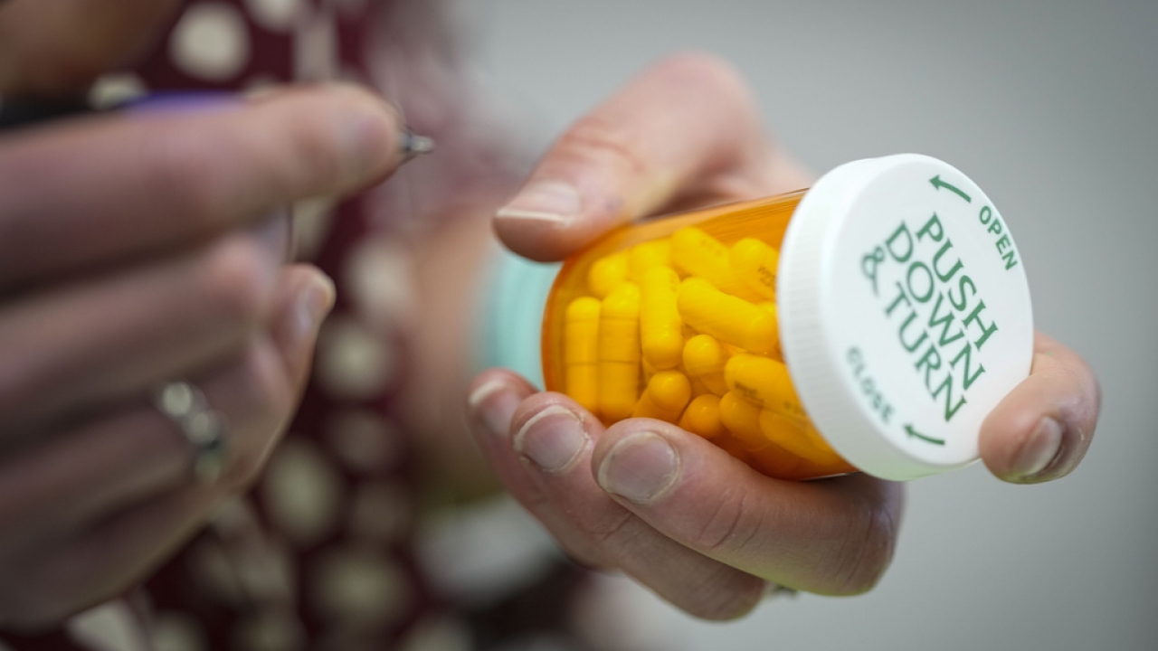 A person holds a pill bottle.