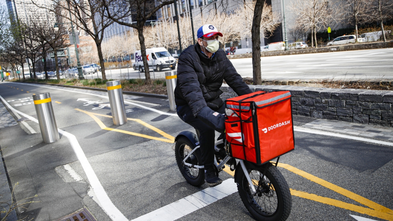 A DoorDash delivery worker rides his bicycle along a bike path on the West Side Highway in New York.