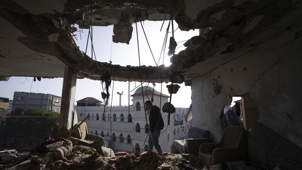 Palestinians look at a damaged residential building after an Israeli strike in Rafah, southern Gaza Strip