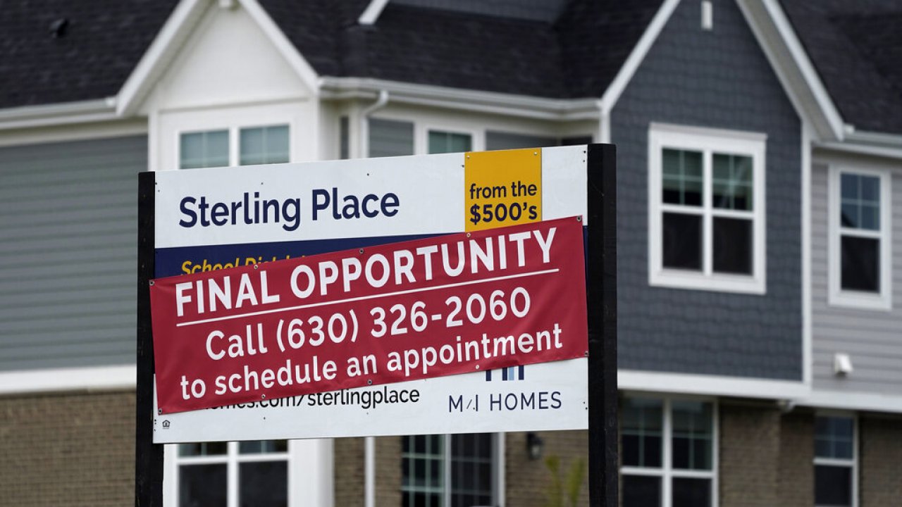 An advertising sign for building land stands in front of a new home construction site in Northbrook, Ill.