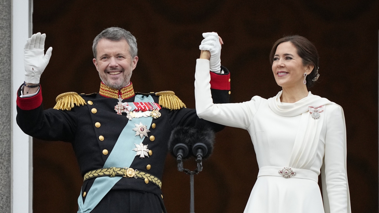 Denmark's King Frederik X and Denmark's Queen Mary wave from the balcony of Christiansborg Palace in Copenhagen.
