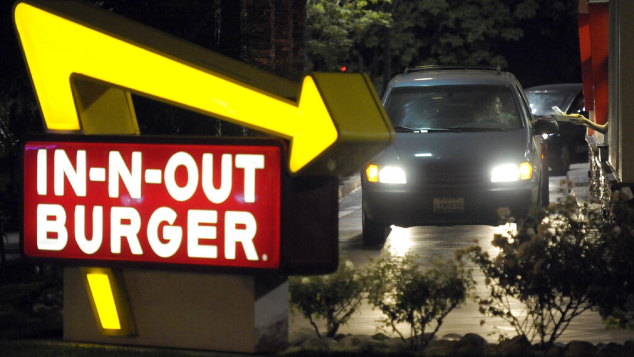 Customer receives an order from the drive-thru at an In-N-Out Burger.