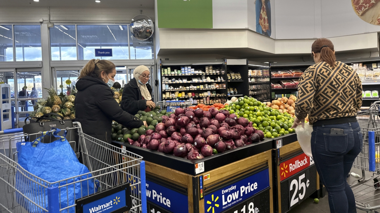 People shop for fruit in a Walmart produce section.