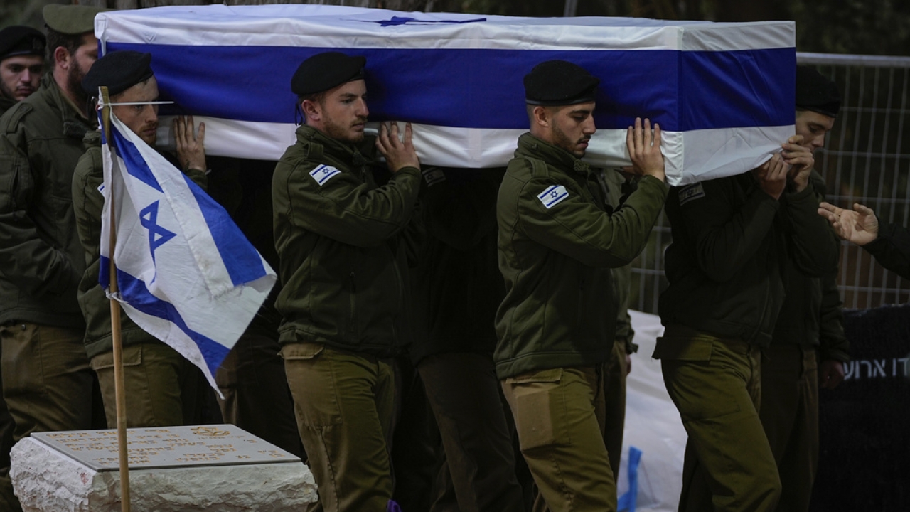 Israeli soldiers carry a flag-draped casket